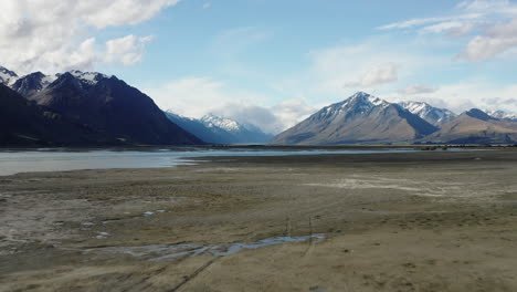 Toma-Aérea-Amplia-Del-Río-Godley-En-Nueva-Zelanda-Con-Montañas-Lejanas,-Agua-De-Deshielo-Glacial-De-Marea-Baja