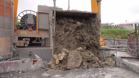 dumping of excavation removed by crane bucket from deep tunnel shaft construction