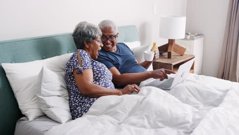 Pareja-De-Ancianos-Acostada-En-La-Cama-Teniendo-Videollamada-Con-Familiares