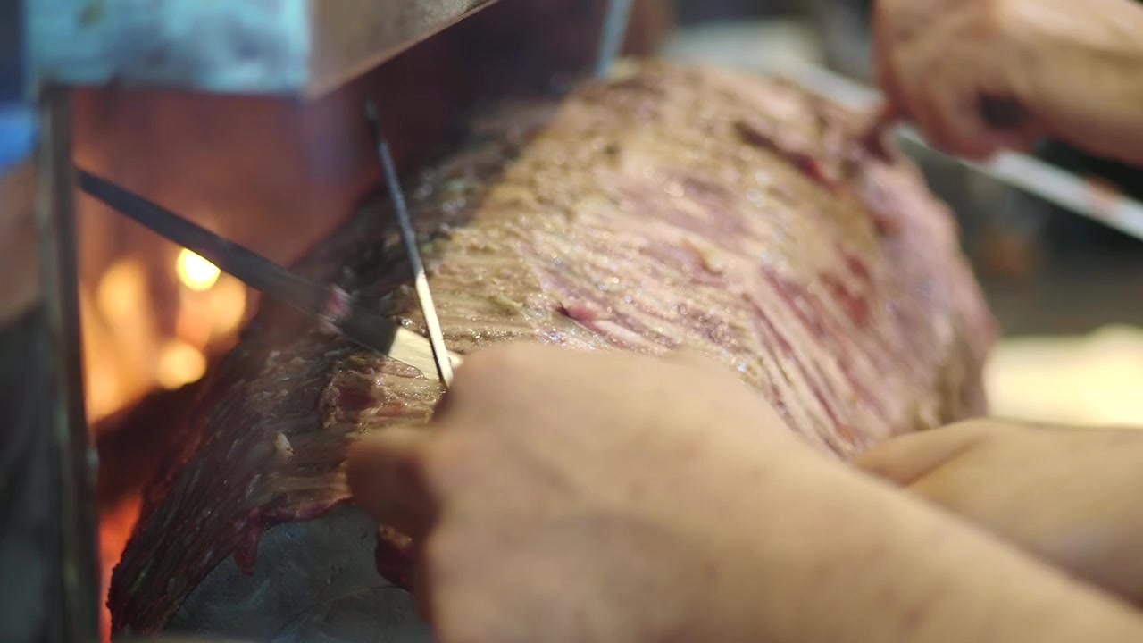 Chef che affetta carne tradizionale per doner kebab su spiedo verticale