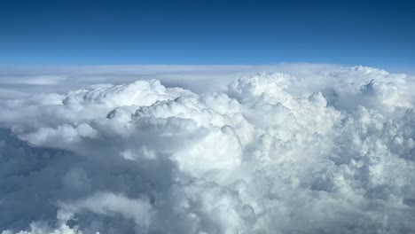 piloto nubes de tormenta pov vistas desde arriba en un cielo azul, disparadas desde la cabina de un avión a nivel de crucero fl300