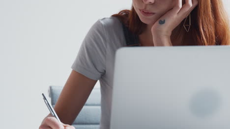 casually dressed young businesswoman with laptop in modern office taking to off camera colleague