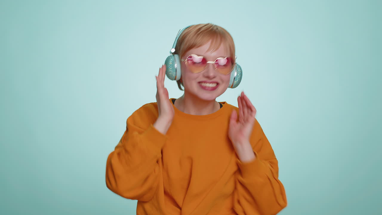 Una donna felice con le cuffie che ascolta musica, danza, discoteca, si diverte, si rilassa alla festa di Natale.