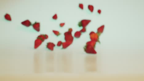 organic health food, fresh and ripe strawberries falling and rolling forward in slow motion, creative concept shot