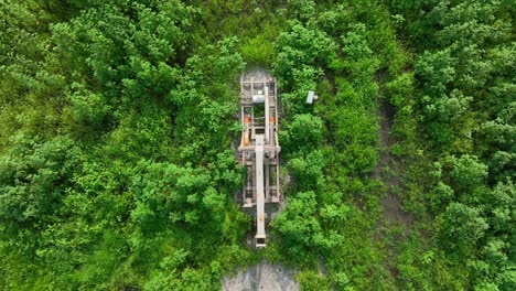 Top-down-aerial-shot-of-oil-well-pumping-crude-oil-out-of-the-ground