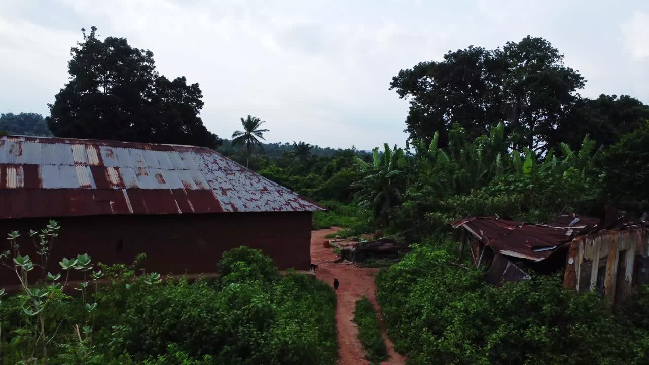 Beautiful dolly in of an old house and a collapsed shed in a rural village in the countryside of Nigeria, Africa