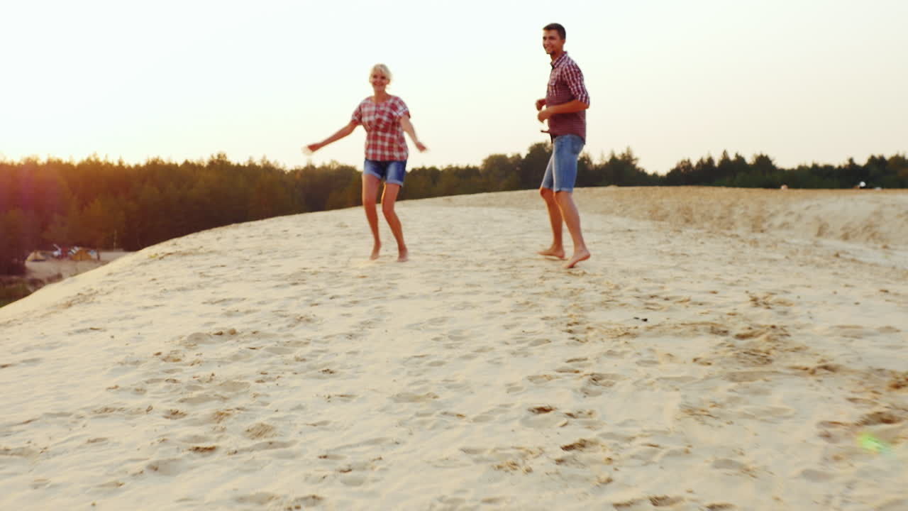 그의 부모와 노는 소녀는 해변에서 모래를 통해 그들을 실행합니다 prores hq 422 10 비트 비디오