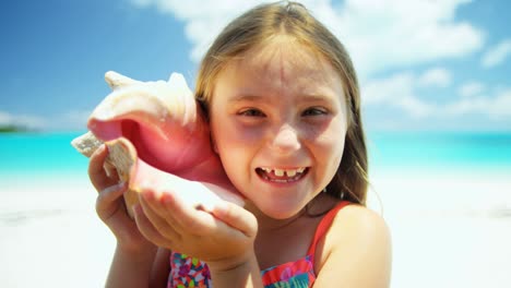retrato de una chica en la playa con una concha de concha