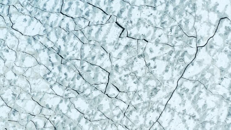 Aerial fly over view of cracked ice in the sea