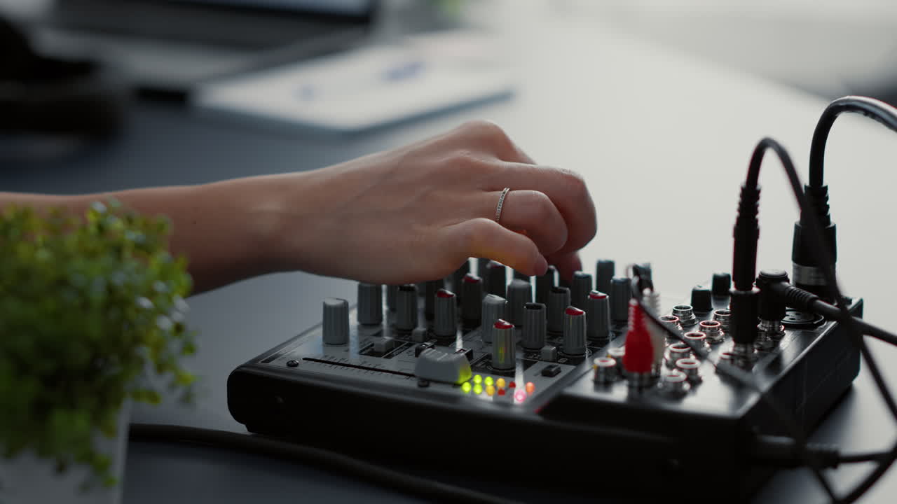 Influencer tweaking audio mixer knobs and buttons