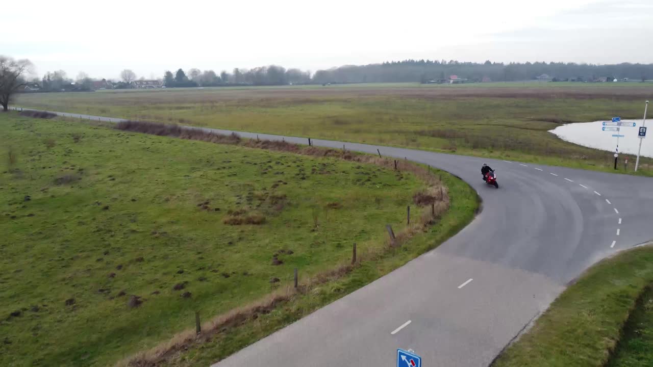 아름다운 자연 공원 한가운데서 길을 운전하는 오토바이 운전자