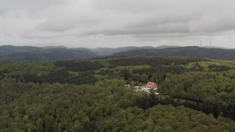 Vista-Aérea-De-Una-Casa-De-Campo-Remota-Rodeada-De-Un-Denso-Bosque-En-Alemania