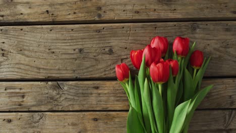 Bouquet-of-red-tulips-on-wooden-background-at-valentine's-day