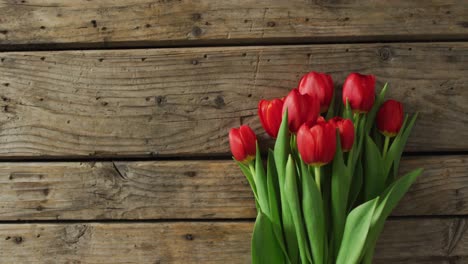 ramo de tulipanes rojos sobre un fondo de madera en el día de san valentín