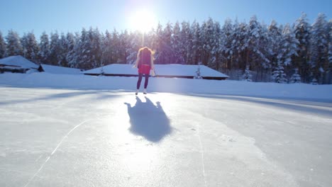 woman ice skating on a frozen lake in winter