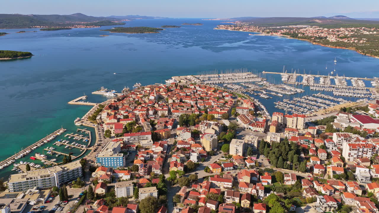 Aerial drone view of Biograd na Moru's old town peninsula, surrounded by turquoise Adriatic waters and multiple marinas filled with yachts. Croatia