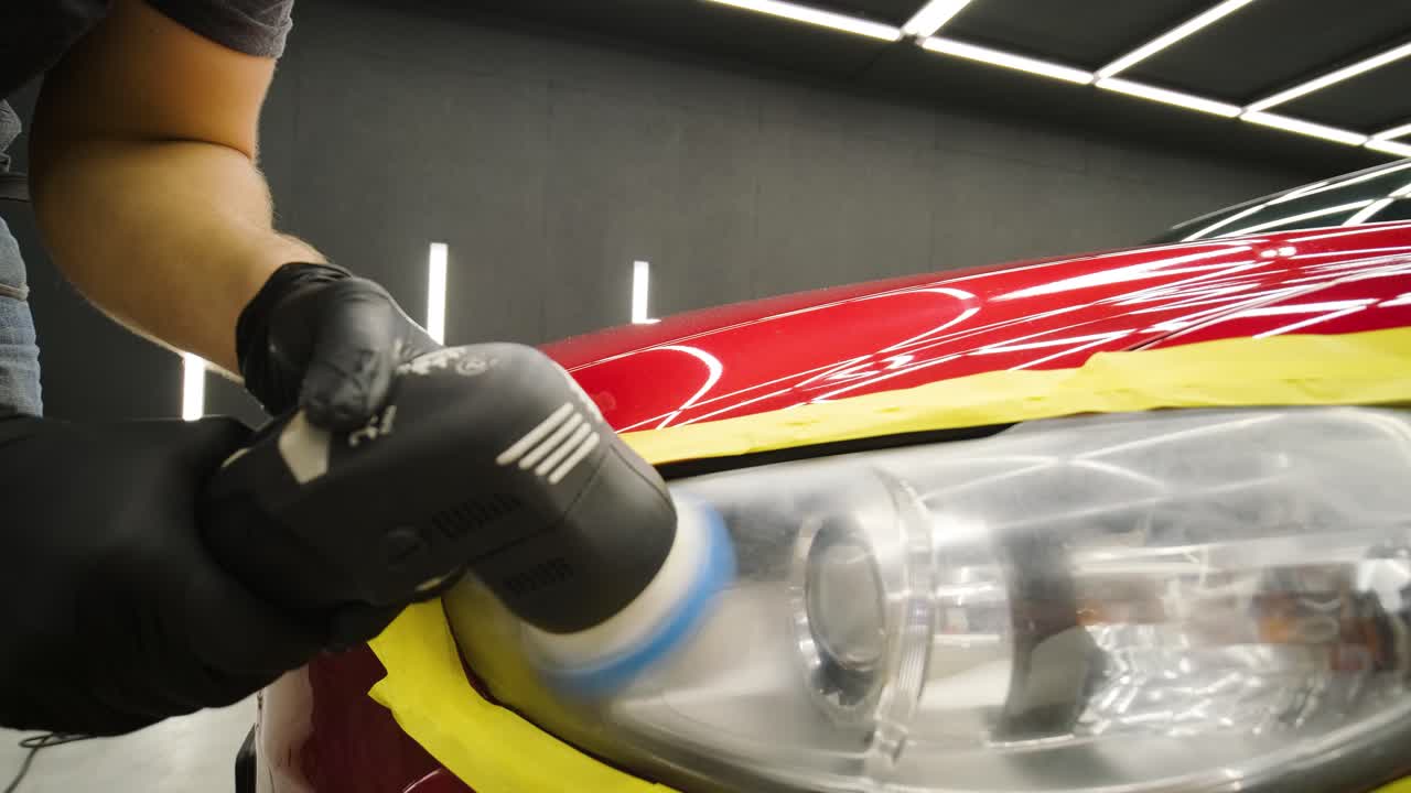 pulido de faros, procesamiento de luces de automóviles. un trabajador de servicio de automóviles pulida el faros de un automóvil de pasajeros. pulido profesional.