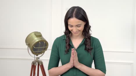 mujer india dando la bienvenida a los invitados
