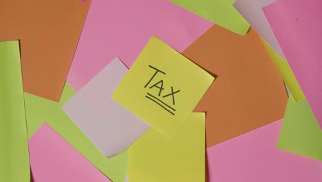 business concept of revolving sticky notes with tax written on top note