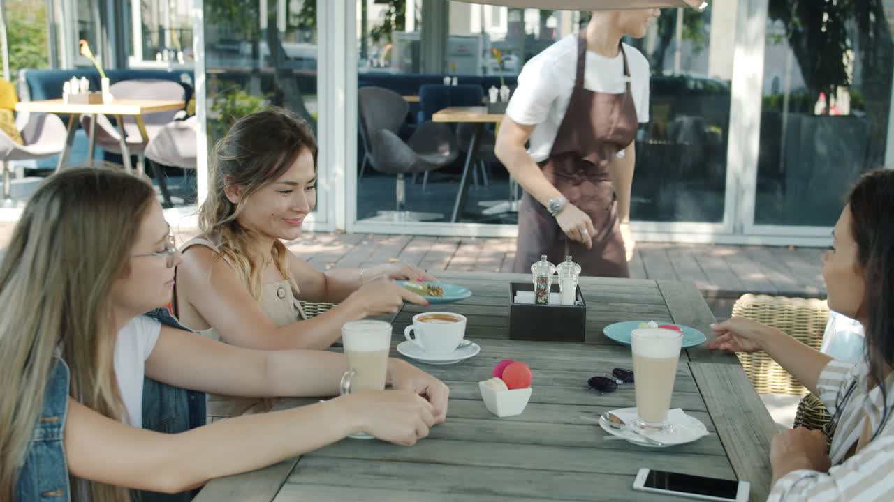 Friends Enjoying Coffee and Dessert at Outdoor Cafe