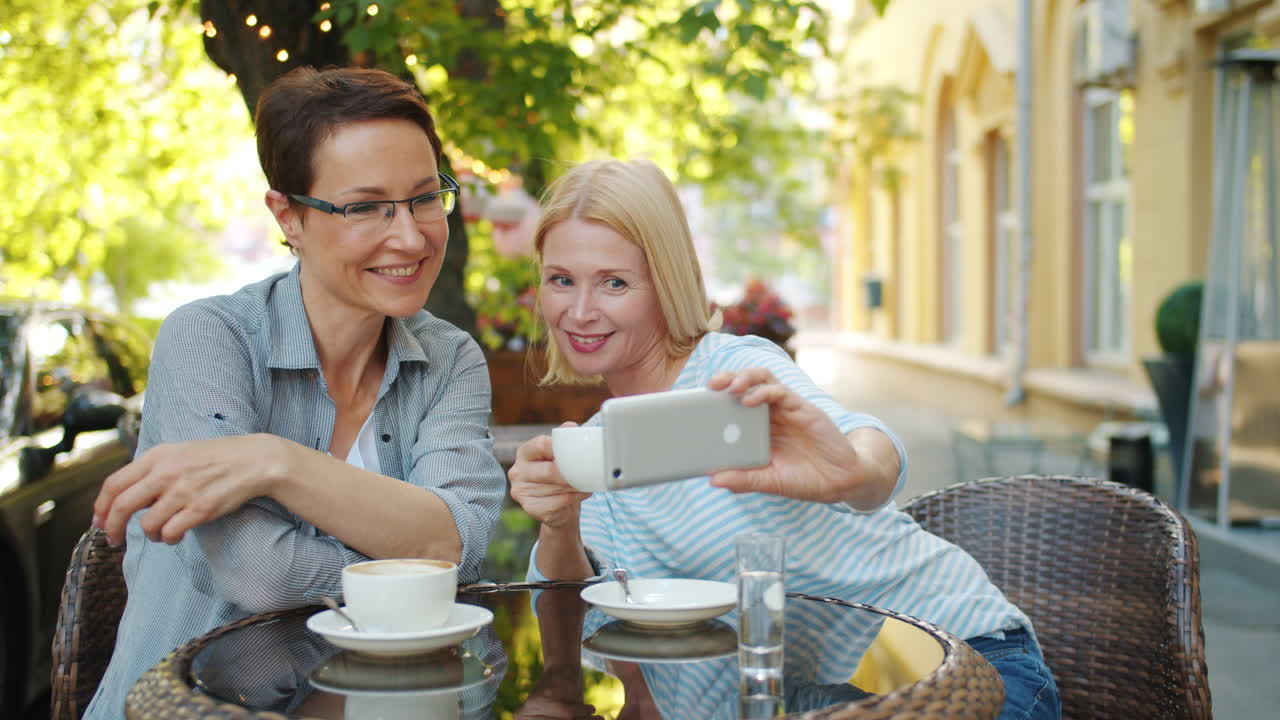 Two Women Taking a Selfie in a Cafe