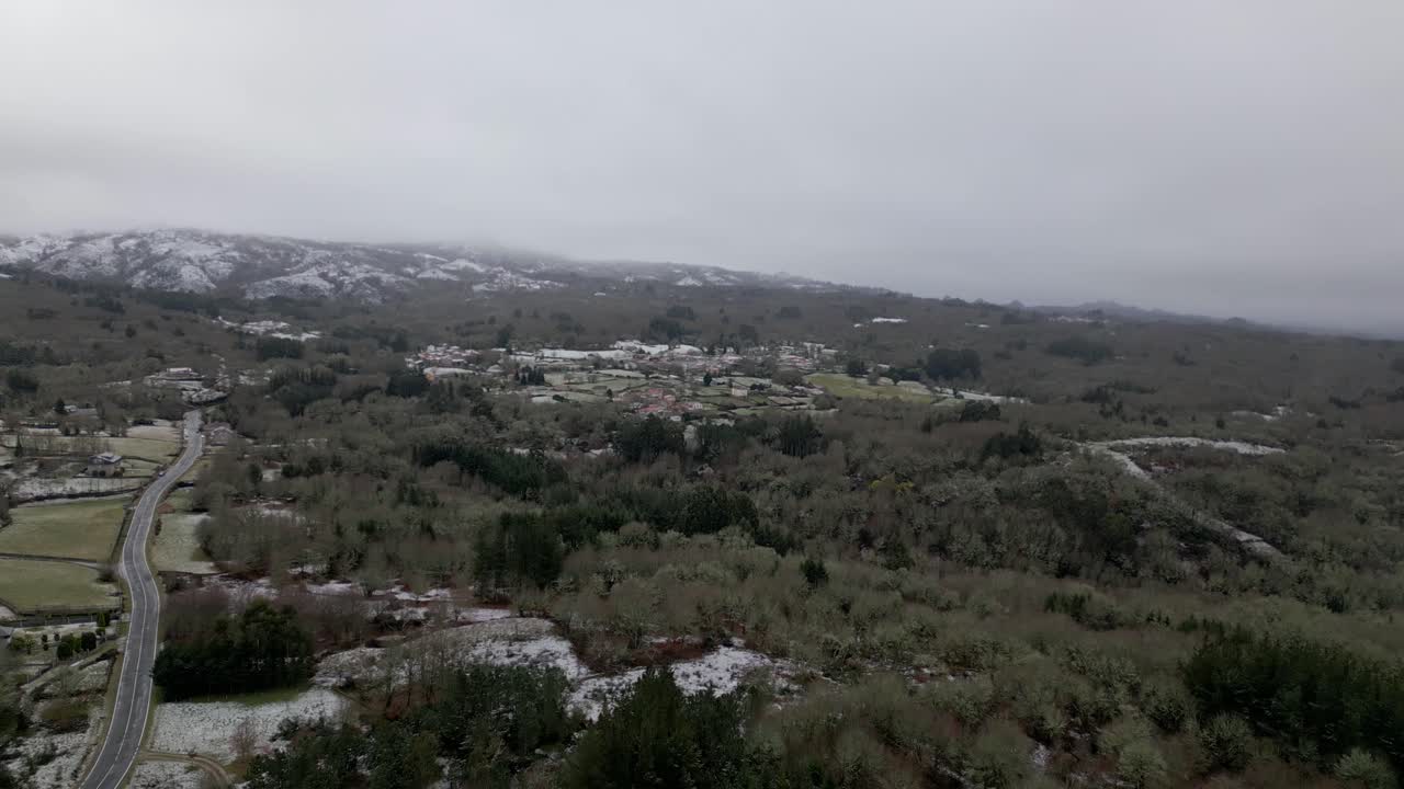 pueblo nevado con vegetación en invierno bajo un cielo nublado en picornio, en galicia
