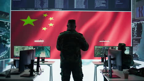 military analyst from china reviews surveillance data in an army monitoring room