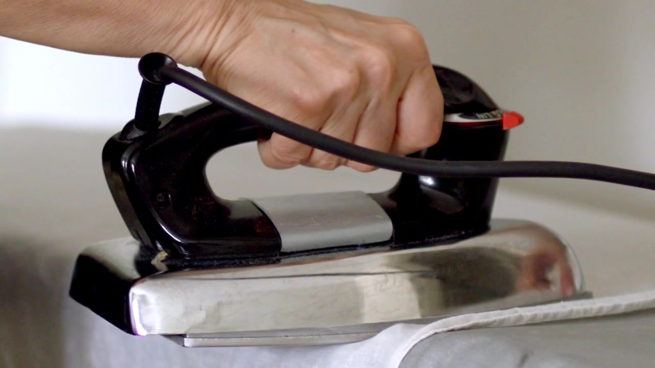 Fresh clean laundry, ironing table equipment, household routine, slow-mo