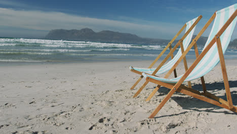 two sunbeds standing on sand at the beach