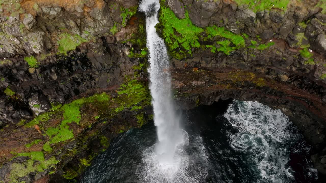 una majestuosa vista aérea de la cascada de múlafossur, que cae en cascada en el océano, islas feroe