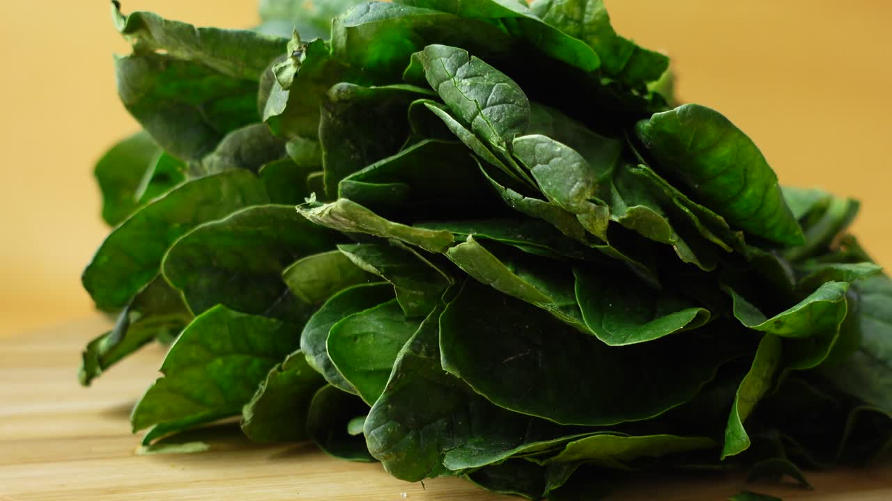 hojas de espinaca frescas en una tabla de cortar de madera