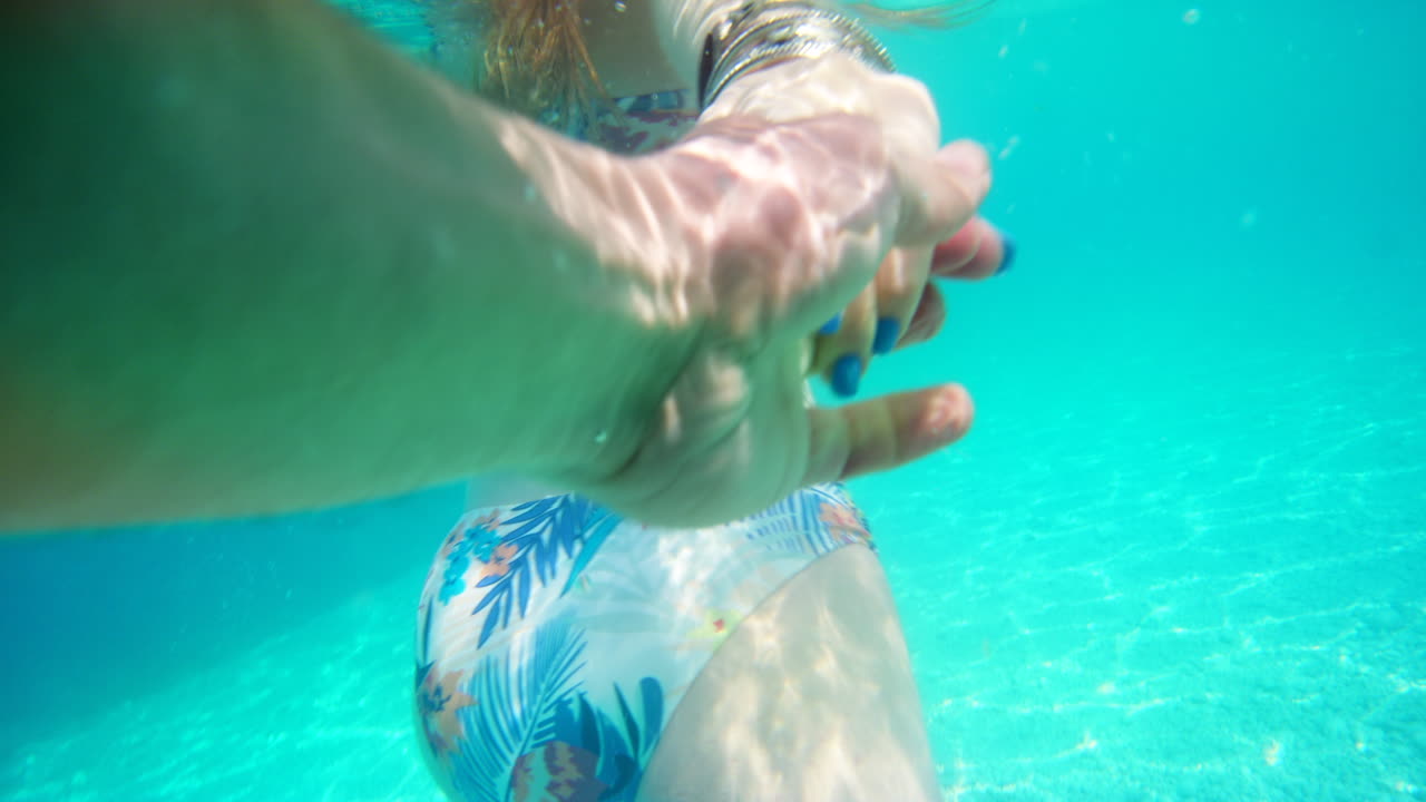 커플, 손을 잡고 파란 수영장에서 수영