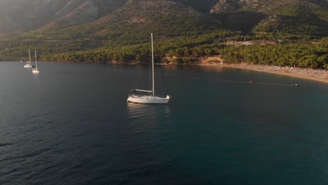 órbita-Aérea-De-Un-Velero-Frente-A-La-Costa-De-La-Famosa-Rata-Zlatni-En-La-Isla-De-Brac-En-Croacia