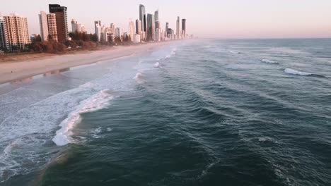 Drone-aerial-during-sunrise-over-city-beach---Surfers-Paradise-and-Broadbeach