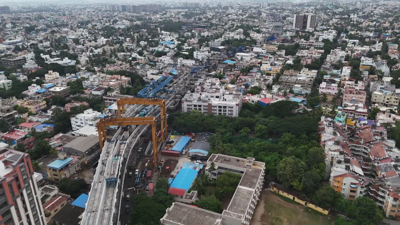 Dynamic aerial footage of Chennai's infrastructure development. Double-decker metro construction, a large rail depot, and a mix of busy roads, showcasing the city's focus on modern public transit