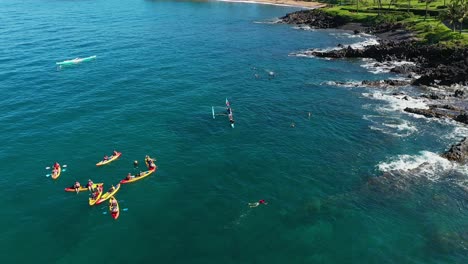 tourist exploring the maui, hawaii coastline by kayak and outrigger canoe