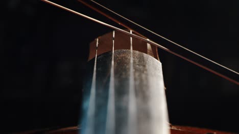 slow motion artistic macro of master artisan luthier playing with a bow on a handmade violin or cello. shot in 8k. concept of spiritual instrument, art, orchestra, passion for music, sound, pre