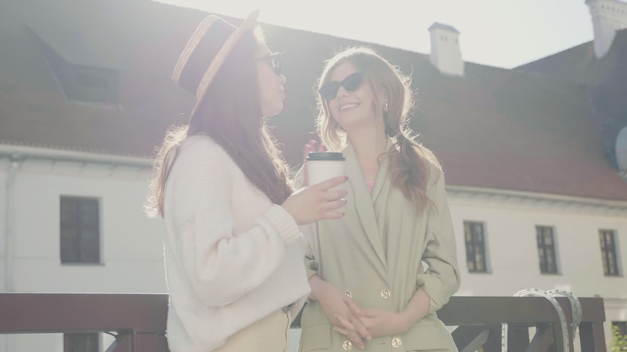 두 명의 여성이 야외에서 커피를 즐기고 있습니다.