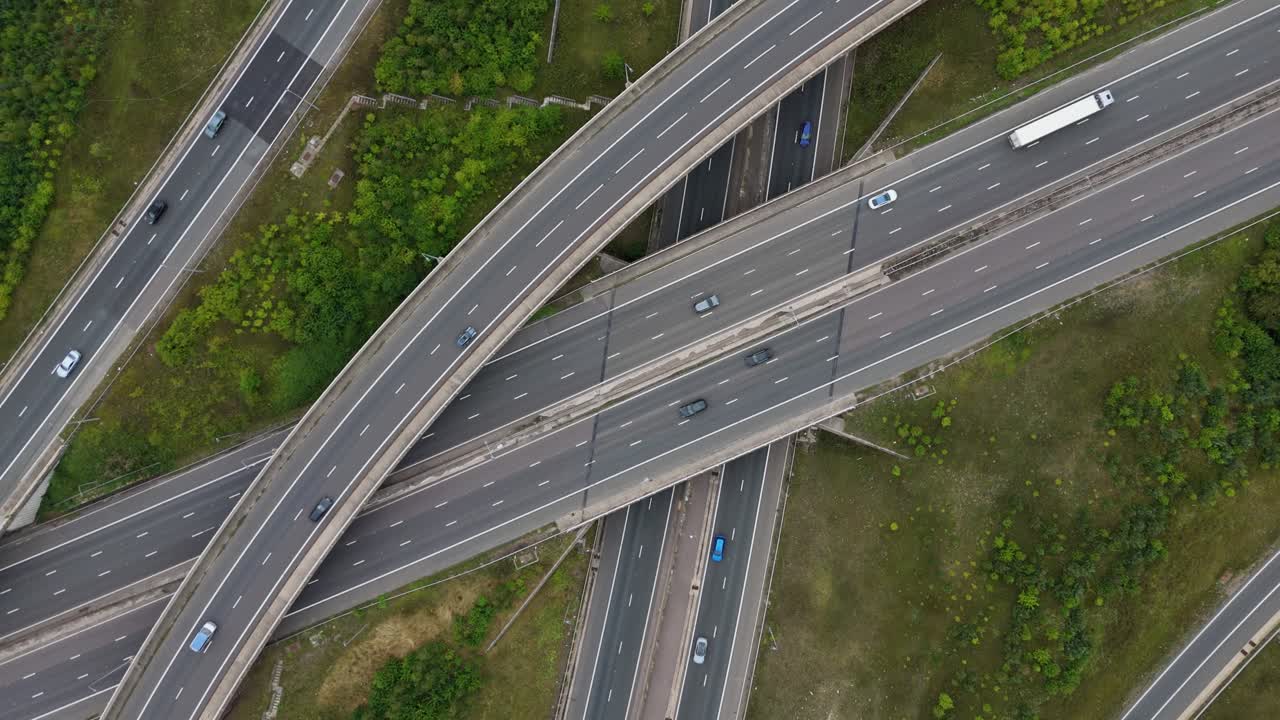 Industrial drone footage of motorway intersection and interchange with busy traffic flow and highway infrastructure near Birmingham UK