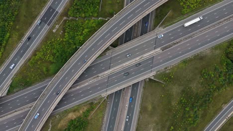 industrial drone footage of motorway intersection and interchange with busy traffic flow and highway infrastructure near birmingham uk