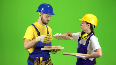 Construction Workers Inspecting Wood