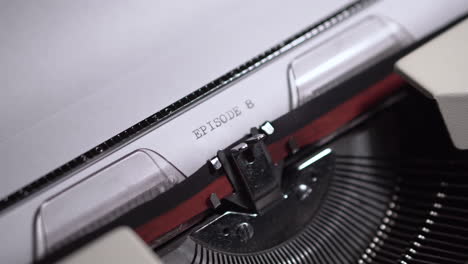 episode 8, typing on white paper in vintage typewriter, writing script or novel, close up