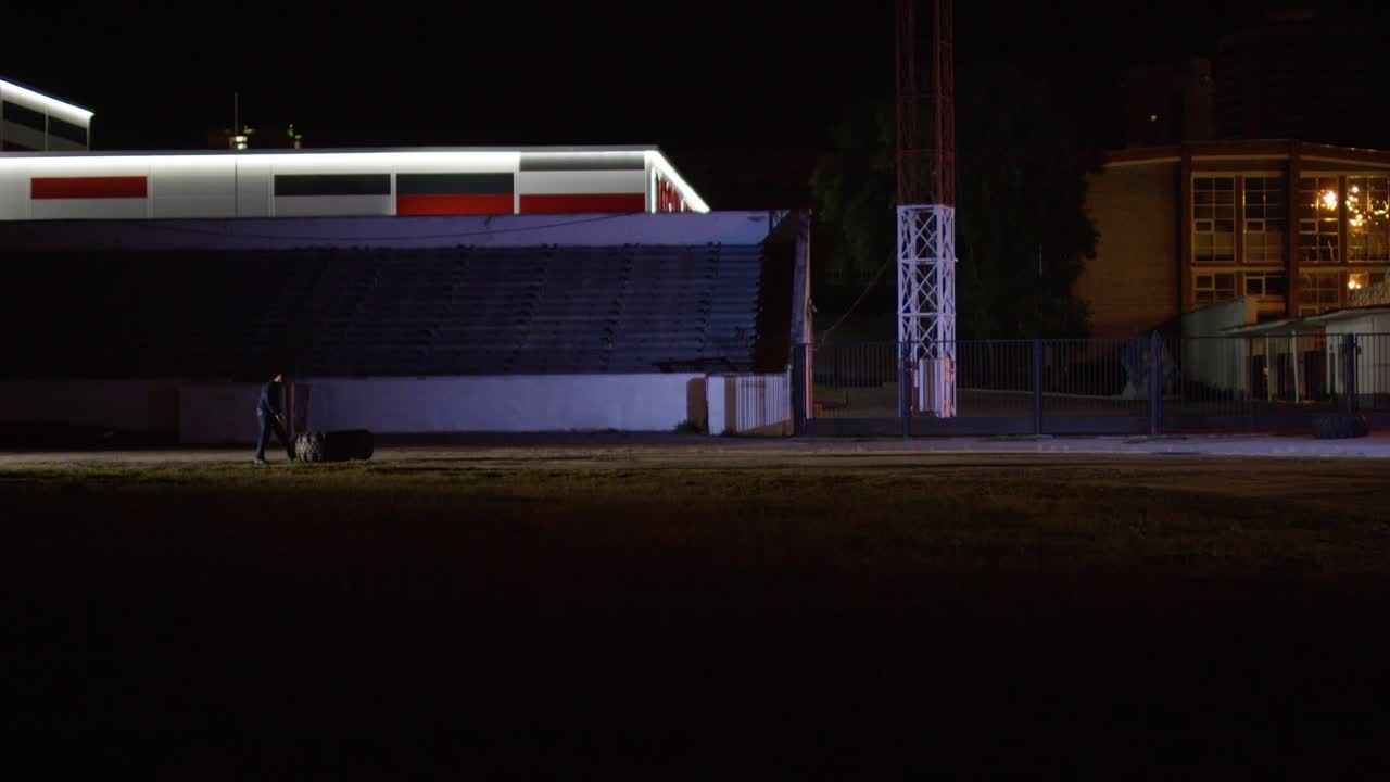 야간 경기장에서 가방을 들고 는 사람