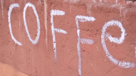 a remote coffee shop with the word coffee painted on a textured red sandstone wall in wadi rum desert, jordan