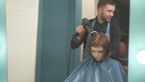 professional hairdresser dyeing hair of woman at salon