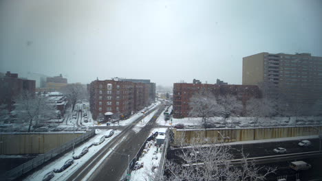 slow motion pan across cityscape in brooklyn, new york city, ny as snow falls heavily on the expressway