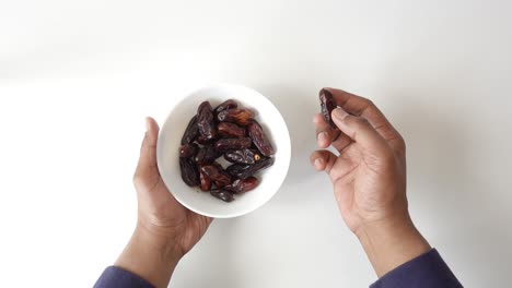 hands holding a bowl of dates