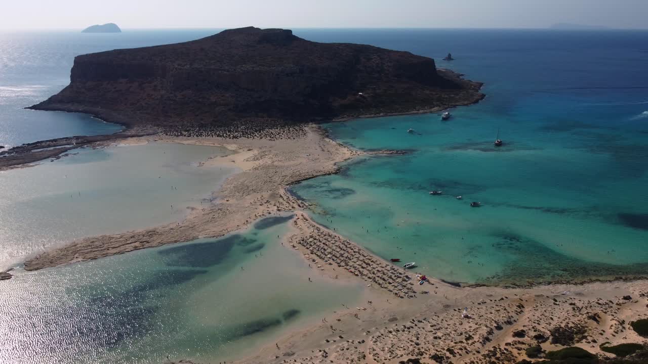 órbita aérea sobre la playa de balos y la laguna llena de turistas, creta, grecia