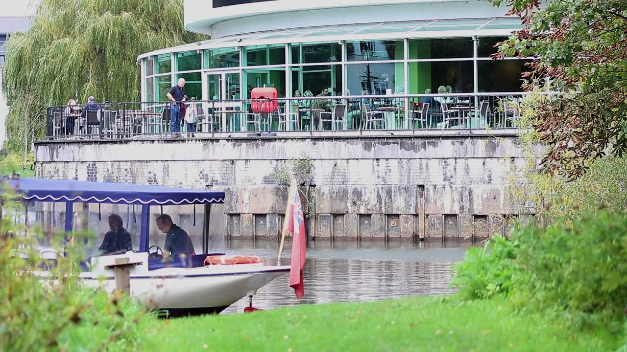 Group of people having a day out on a boat navigating the River Wey at Guildford in Surrey, England.