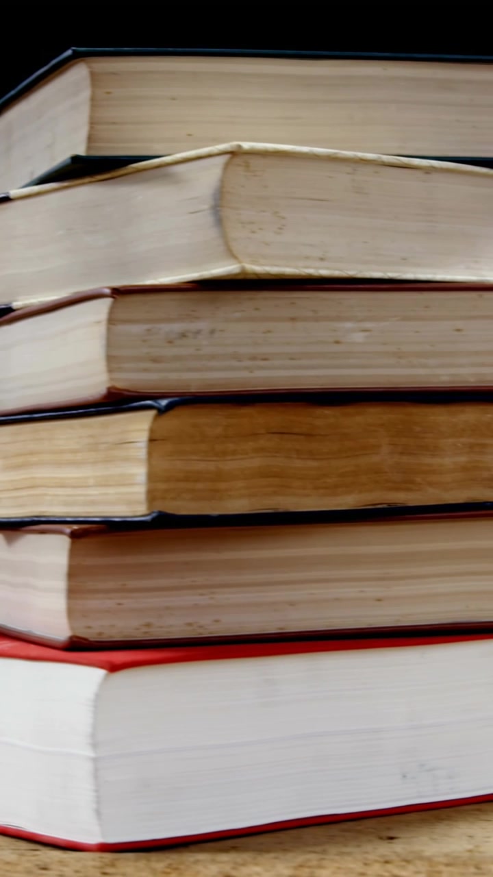 School concept icons against stack of books on wooden surface